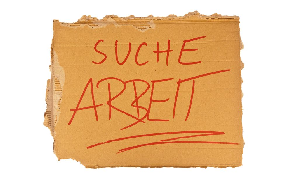 Das Schild aus Karton eines Obdachlosen. Isoliert auf wei?em Hintergrund